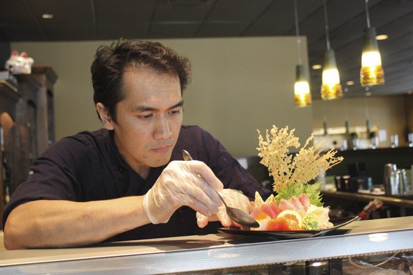 Issho Restaurant co-owner and head chef Harry Amirullah puts the finishing touches on a plate of sashimi