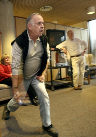 Gene Francis watches the screen as he takes his turn bowling while trying out the new Nintendo Wii System at the Redmond Senior Center. A local teen