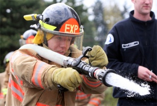 Redmond Fire Explorer Ben Darr hits a target with a charged hose during the Combat Challenge Relay at Saturday's Fire Muster Invocation at the King County Fire District 20's training center in Skyway. Fire Explorers from around the region competed in a variety of firefighting and emergency medical skills at the competition. The participants are between the ages of 14 and 21 and they are youths who are interested in firefighter/medical emergency services careers. Many fire departments