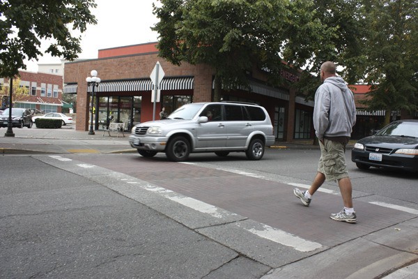Redmond traffic lieutenant Doug Kruger enters the crosswalk on Cleveland Street as part of the Redmond Police Department's pedestrian enforcement Tuesday morning. On a two-lane road