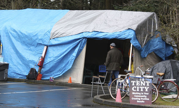 A Tent City 4 resident stands near the front desk of the homeless camp