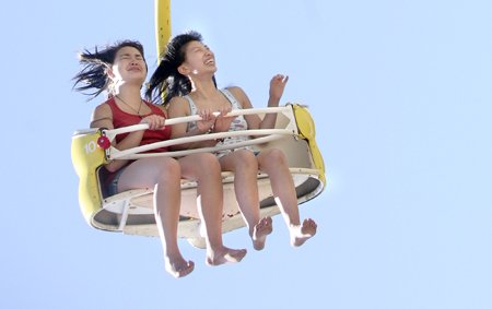 Annie Yu and Felicia Romero close their eyes as The Paratrooper ride spins faster at the carnival during last summer's Derby Days Festival.