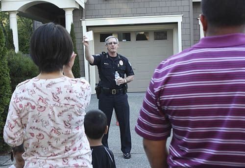 Redmond Police Chief Ron Gibson discusses crime prevention and personal safety with residents at a National Night Out Against Crime block party last August.