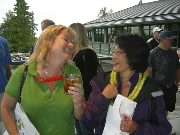 Diana Merritt (left) from Landover Mortgage and Corrine Passavant enjoy a fun moment on the patio near the silent auction and bar at Monday's Greater Redmond Chamber of Commerce annual golf tournament and auction. Merritt is an avid golfer and chair of the chamber's Ambassadors committee and is a new member of Board of Directors. Corrine