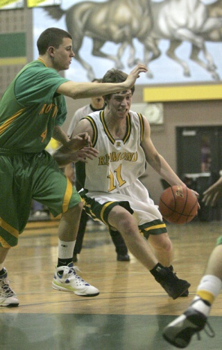 Redmond guard Chris Harrington drives in for two of his 10 points while Roosevelt's Louis Voorhees defends. The Mustangs had their six-game win streak snapped on Tuesday by the Roughriders