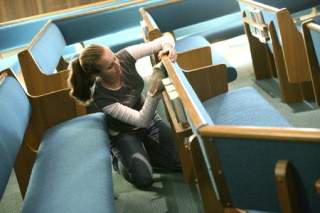 Amy Hammond dusts some of the pews at the First Baptist Church during The Bear Creek School Community Service Day on Wednesday.