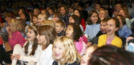 Kids at Laura Ingalls Wilder Elementary School crack up during a 'blast from the past' slide show at the school's 20th birthday celebration on Dec. 11. The slide show featured photos of staff members with '80s hairdos and fashions and theme songs from classic TV shows including 'Seinfeld' and 'St. Elsewhere.'