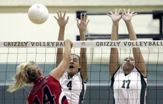Bear Creek’s Dominique DuBois (No. 4) and Alexis Miller (No. 17) go up for a block against King’s West’s Liz Johnson during the Grizzlies’ 3-2 win over the Warriors at The Bear Creek School last Thursday night.