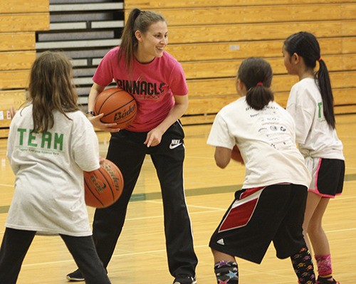 Ashley Graham discusses an upcoming drill with players at the Redmond Girls Basketball Camp in June at Redmond High School.