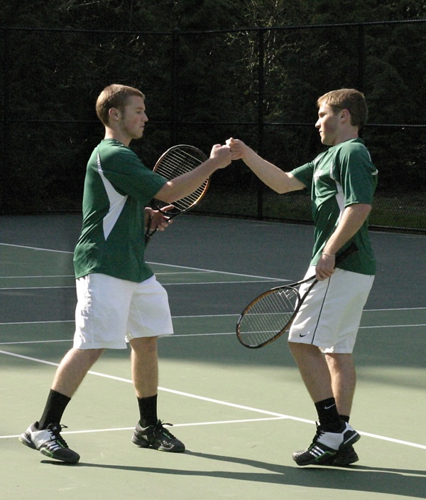 Senior twins Grant (left) and Marcus Munoz bump fists after winning a crucial point in their 6-3