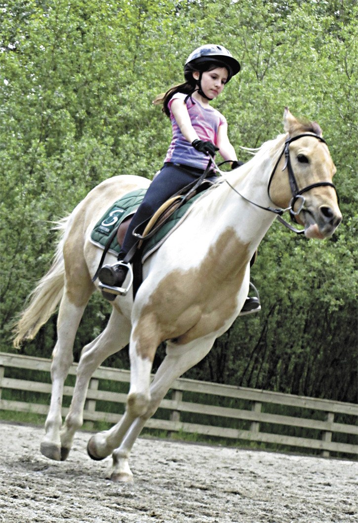 Twelve-year-old Elizabeth Copeland canters through the Farrel-McWhirter Riding School arena.