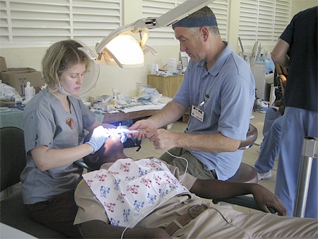 Dr. C.R. Anderegg assists a dental student from Temple University School of Dentistry working on the teeth of a patient in Jamaica. Anderegg and his staff will be heading back to Jamaica for a third time this November as part of Great Shapes! Inc. “1