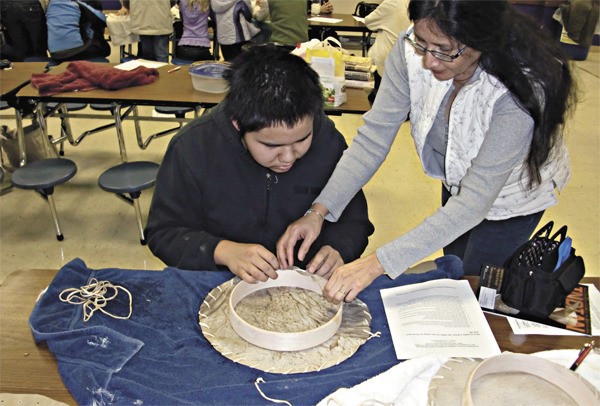 Carlo Douglas and her son Daryl work together to make a drum during an Eastside Native American Education Program (ENAEP) meeting at Lake Washington High School. The program works with students from Lake Washington
