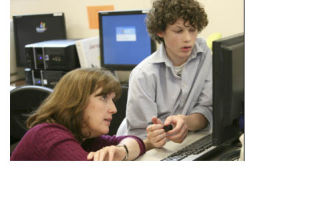 The Bear Creek School’s journalism teacher Kristen Sanger helps student Will Stansell locate a file on a computer during class on Wednesday
