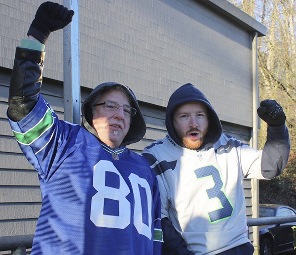 Father and son Craig and Max Salathe wait to board the 545 SoundTransit bus in Redmond this morning to get to the Seattle Seahawks downtown victory parade.