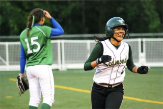 Redmond senior Maria Reisinger is all smiles after hitting a two-run home run in the fourth inning as dejected Woodinville pitcher Maria Gau stands in the background. The Mustangs won