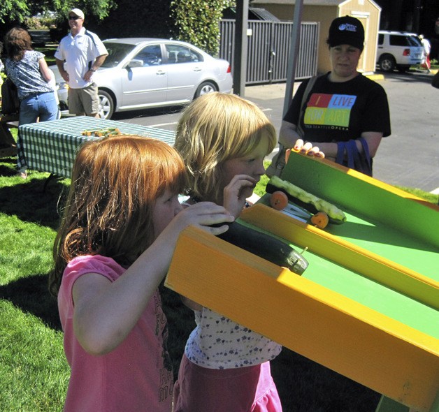 Sisters Lilliana (left) and Ruby Ponder prepare to race their vegetable cars down the track during the Redmond Zucchini 500 at the Redmond Saturday Market. Lilliana won the race.