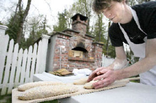 Bread baker Ross Tasche quickly preps loaves of sourdough to go into an old world style oven in the backyard of his familys home in Redmond.