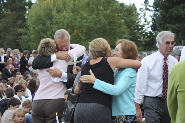 Family and friends embrace after a public memorial for Jackson Roos