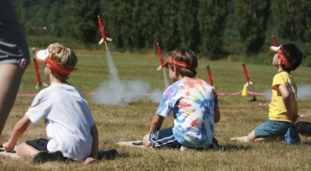 Local youth launch rockets at 60 Acres Park in Redmond last Friday as part of the Champions Science Adventures summer camp grand finale. The rocket launch was the highlight of the week for many campers.