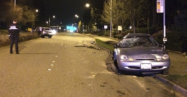 A Bellevue Police Department investigator examines a two-car crash on 148th Avenue Northeast on Thursday morning.