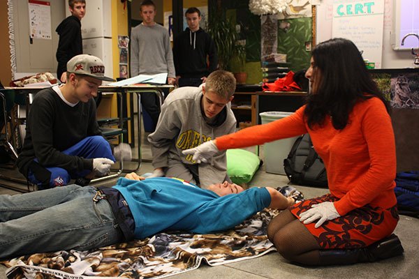 Catherine Robinson (right) instructs students on how to check a person for injuries during Tuesday's CERT class at Redmond High School.