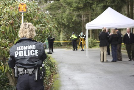 Redmond Police investigators survey the scene after a body was found in the ivy greenbelt near an office building at 15446 Bel-Red Road Wednesday afternoon.