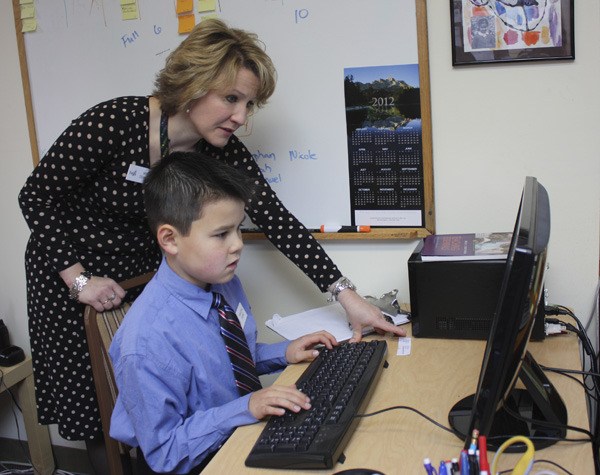 Faith Lutheran School principal Barbara Deming helps third grader Hayden Wong check his email. The 8-year-old was principal for a day last Friday and performed many of the duties Deming does on a daily basis.