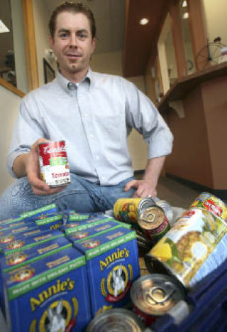 Physical therapist Ben Wobker displays a bin of non-perishable food items that have been brought in by patients in lieu of missed appointment fees. All of the food collected will be donated to Hopelink.