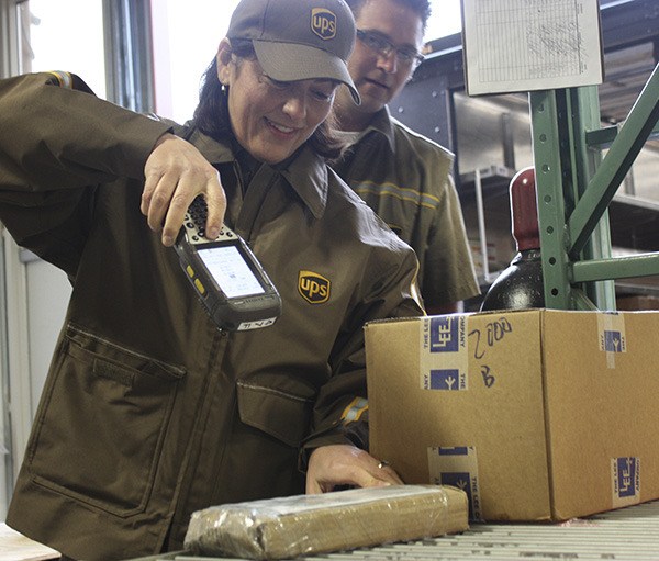 Congresswoman Suzan DelBene scans a package while UPS delivery driver Mike Vallimont watches on Wednesday morning at Triumph Aerospace Group on Redmond Ridge. DelBene