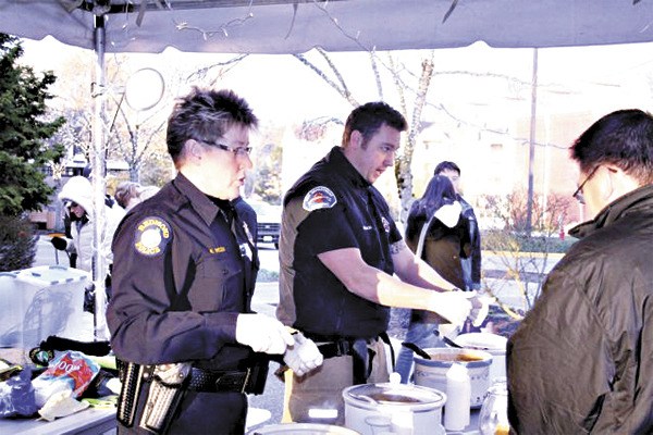 Redmond Police Commander Kristi Wilson (left) and Redmond Firefighter Paul Atkinson compete in last year's chili cook-off at the Redmond Lights Winter Festival. The popular event returns this year and the field will be expanded to include city councilmembes as well as staff from the Redmond Police and Fire Departments.