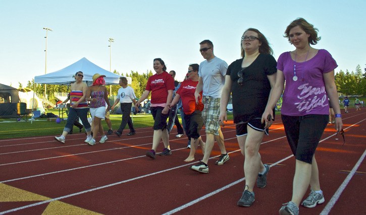 Local participants circle the track at Redmond High School to help raise money for the American Cancer Society's Redmond-Kirkland Relay for Life on Saturday. So far