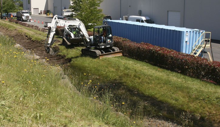 Crews dig up soil from the bioswale — a drainage ditch that helps filter polluted stormwater before entering a drain that feeds into a nearby creek — near the Sammamish substation. Crews will test the soil for any mineral oil or foam contamination caused by last week's transformer fire.