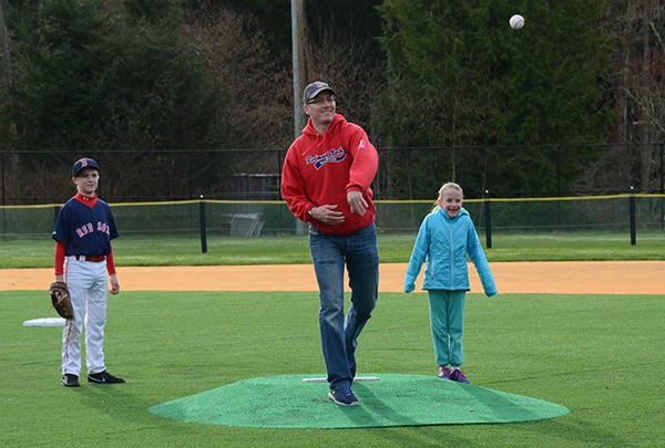 Bryan Roos (center) threw out the ceremonial first pitch at the newly renovated Jackson Roos Memorial Field at Redmond Ridge Park.