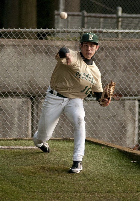 Redmond junior Dylan Davis lets go of a pitch during a recent Mustang baseball practice. Davis led the team in ERA (1.41) and wins (6) last year for the 'Stangs