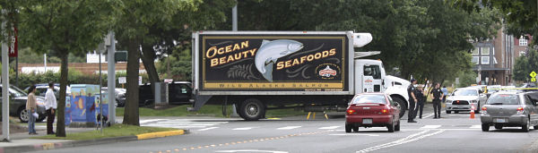Redmond police direct traffic as an Ocean Beauty Seafoods delivery truck moves up Northeast 85th Street at 12:30 p.m. today. The truck