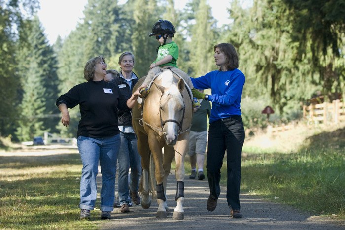 Four-year-old Magnus (last name withheld) rides a horse for hippotherapy as
