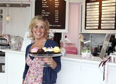 PinkaBella Cupcakes owner Margo Engberg shows off a bounty of beautiful cupcakes at her shop on the upper level of Redmond Town Center. Formerly known as Pinkalicious