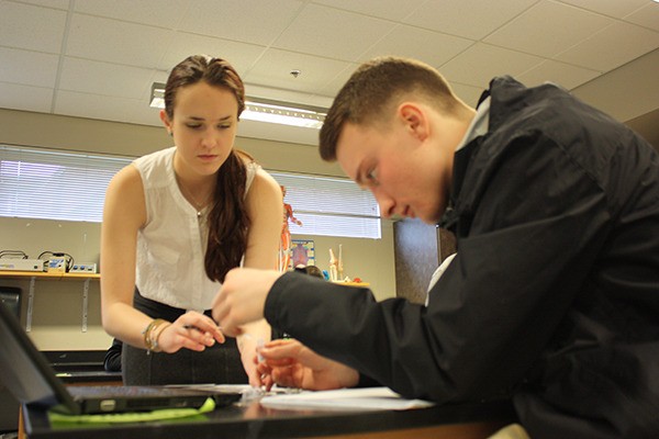 Former Redmond High School students Sarah Herron (left) and Thomas Barnett work together on a lab during a class last year for the STEM signature program. The program is focused on global health.