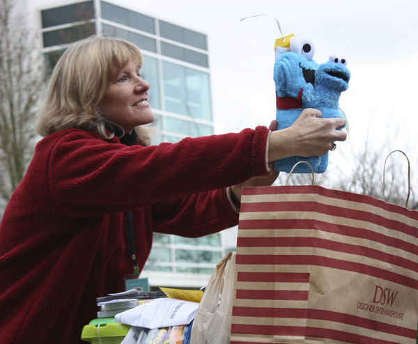 Kris Betker of Redmond-based Hopelink shows off a Tickle Me Cookie Monster on Thursday morning during the Giving Tree volunteer present pick-up event on the Microsoft campus.