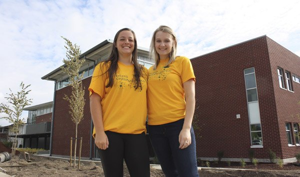 Redmond High School seniors Andrea Larson (left) and Danielle Skinner have been working with staff and administration to prepare the school for the incoming freshmen and sophomores. They are standing in front of the school's new wing.