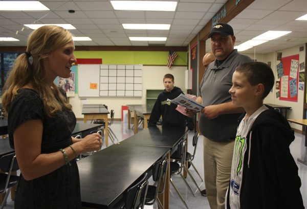 Evergreen Middle School science teacher Kelsie Fowler (left) shares a few details with sixth-grader Ashtonn Hoffmann about what's in store for him this upcoming school year. The meeting was part of an orientation event for new students and their families to learn the school and meet teachers.