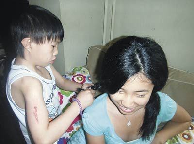Moses skillfully braids Hannah Yang’s hair while she visits Shepherd’s Field Children’s Village in Langfang