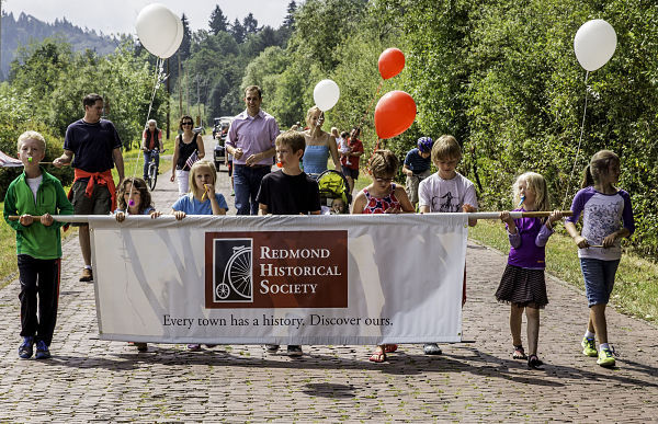 'The Kids of Red Brick Road' kick off Saturday's 100th year anniversary parade.  The local children (carrying a banner) were followed by the Evergreen Model 'A' club along the 1.3-mile route. Saturday's celebration ended with a short speech by Redmond Mayor John Marchione and The Redmond Historic Society.