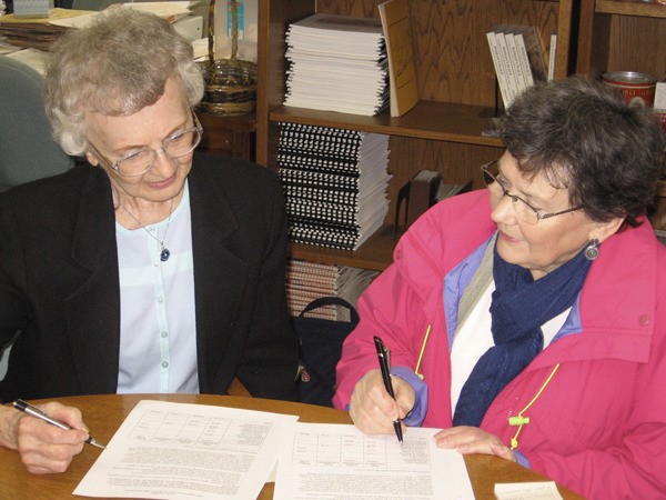 Doris & Judy. Doris Schaible and Judy Lang review oral history transcripts at the Redmond Historical Society office.