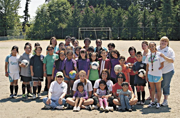 OLE Committee members pose for a photo with a group of kids at a recent OLE soccer practice at Einstein Elementary in Redmond. Front row