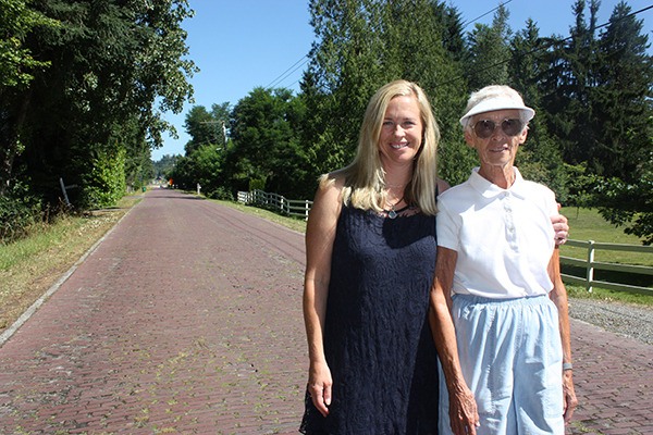 Tanya Rusak (left) and Carolyn Hudson live along the Red Brick Road just outside of the City of Redmond limits. An event celebrating the bricks’ centennial will be held on Saturday.