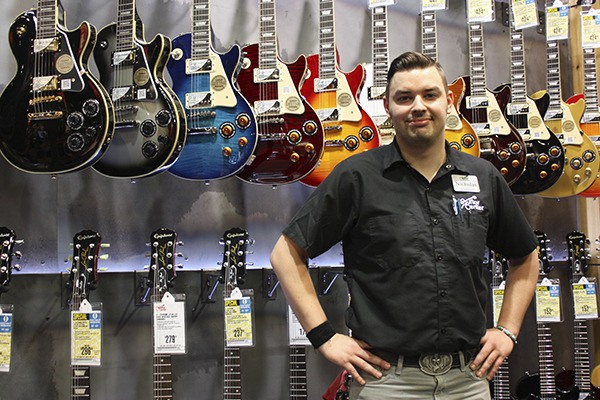 Redmond Guitar Center manager Nick Stejer stands in front of a wall of Gibsons on Wednesday afternoon. The store held its grand opening on Thursday.