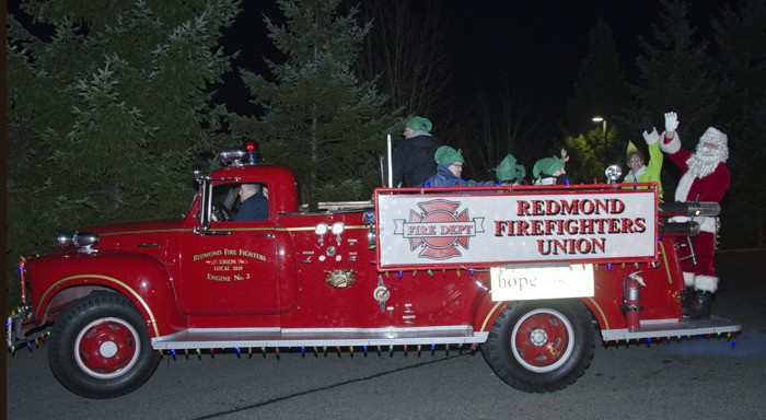 Redmond Fire Apparatus Program Supervisor Doug Jones (Santa) and Redmond Fire Mechanic Brian Barrett (Buddy the Elf) spread some holiday cheer through the Grass Lawn neighborhood Monday night. The tour will continue tonight in southeast Redmond and will go other Redmond neighborhoods throughout this week and the weekend.