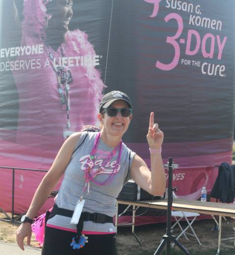Christi Dudzik of Woodinville flashes a No. 1 sign to a friend at Marymoor Park on Friday afternoon after finishing her first day of walking in the Susan G. Komen Seattle 3-Day.